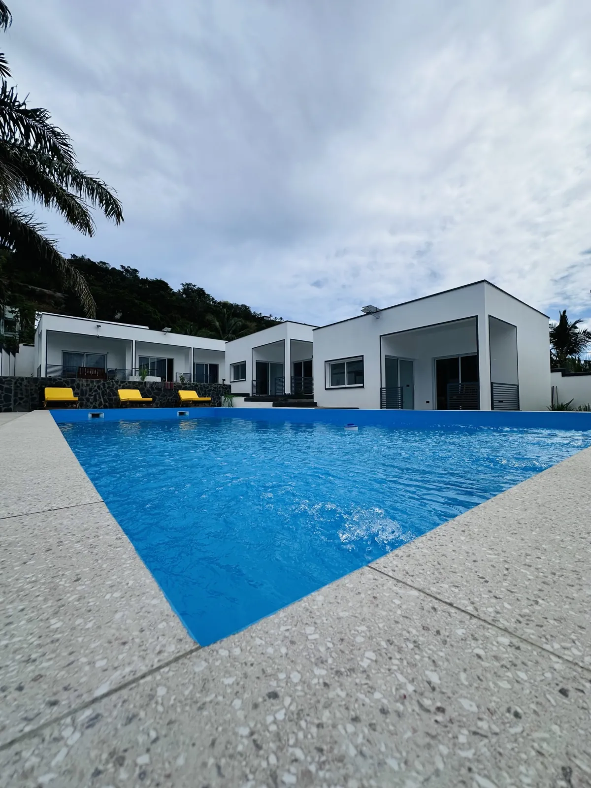 La piscine turquoise devant les appartements blancs